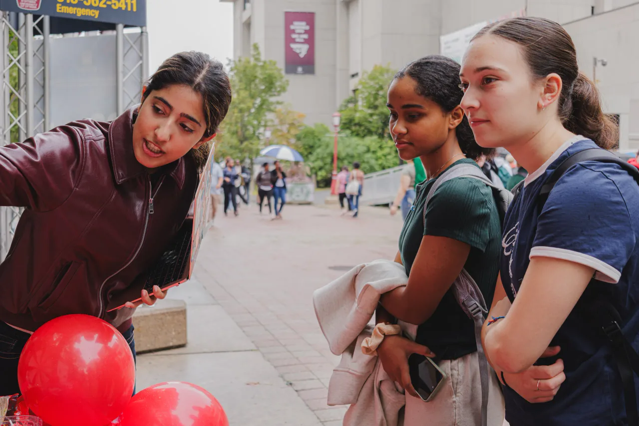 A member talking with two students at the club table