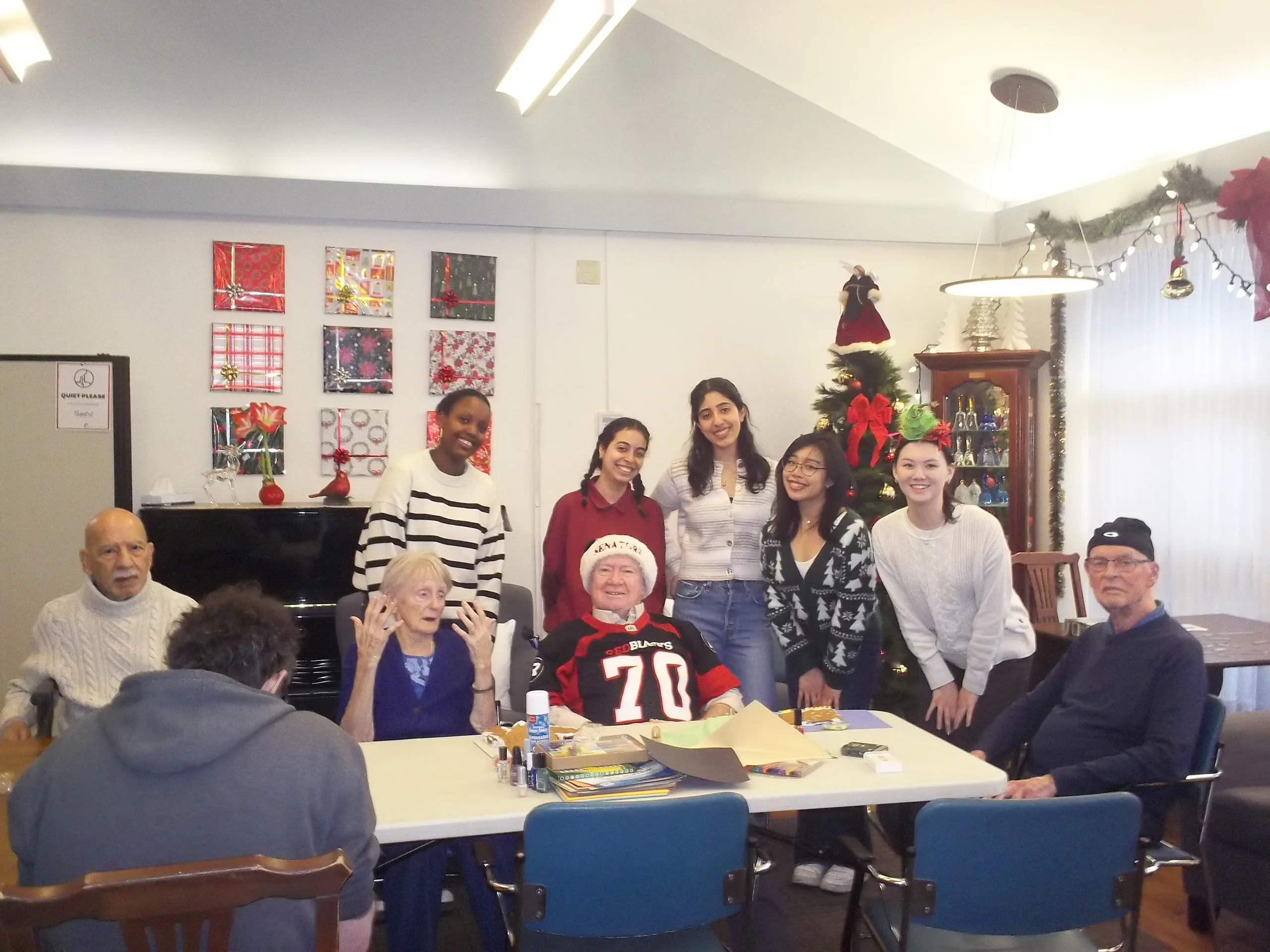 Circle K members standing with residents around a craft table at a holiday visit